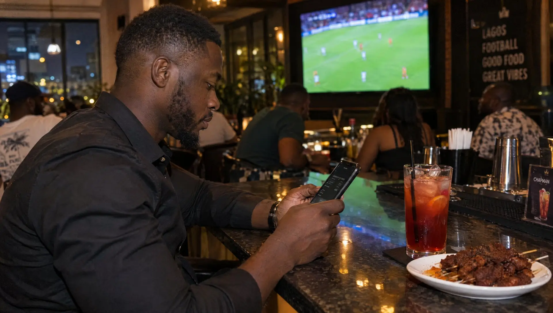 A Nigerian man checking a bet slip on his phone at a Lagos sports bar with a football match on the TV behind him