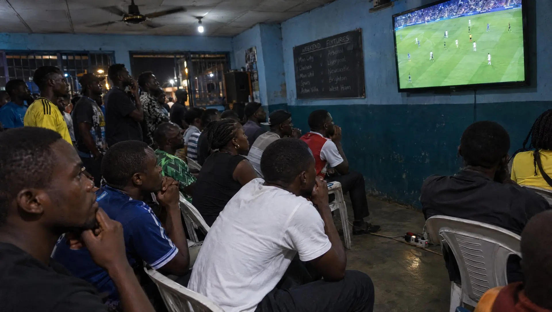 Nigerian football fans watching a Champions League match on a big screen at a Lagos viewing centre